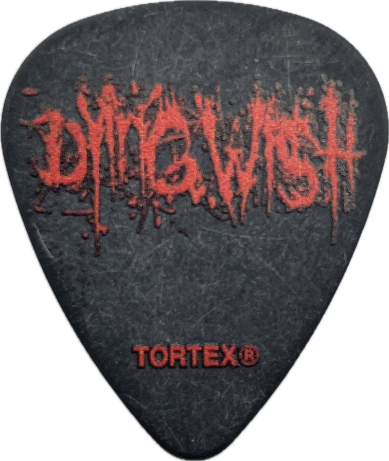 Front of a black Dying Wish Tortex guitar pick with red Dying Wish logo and Dunlop Tortex mark Front of a black Dying Wish Tortex guitar pick with red Dying Wish logo and Dunlop Tortex mark