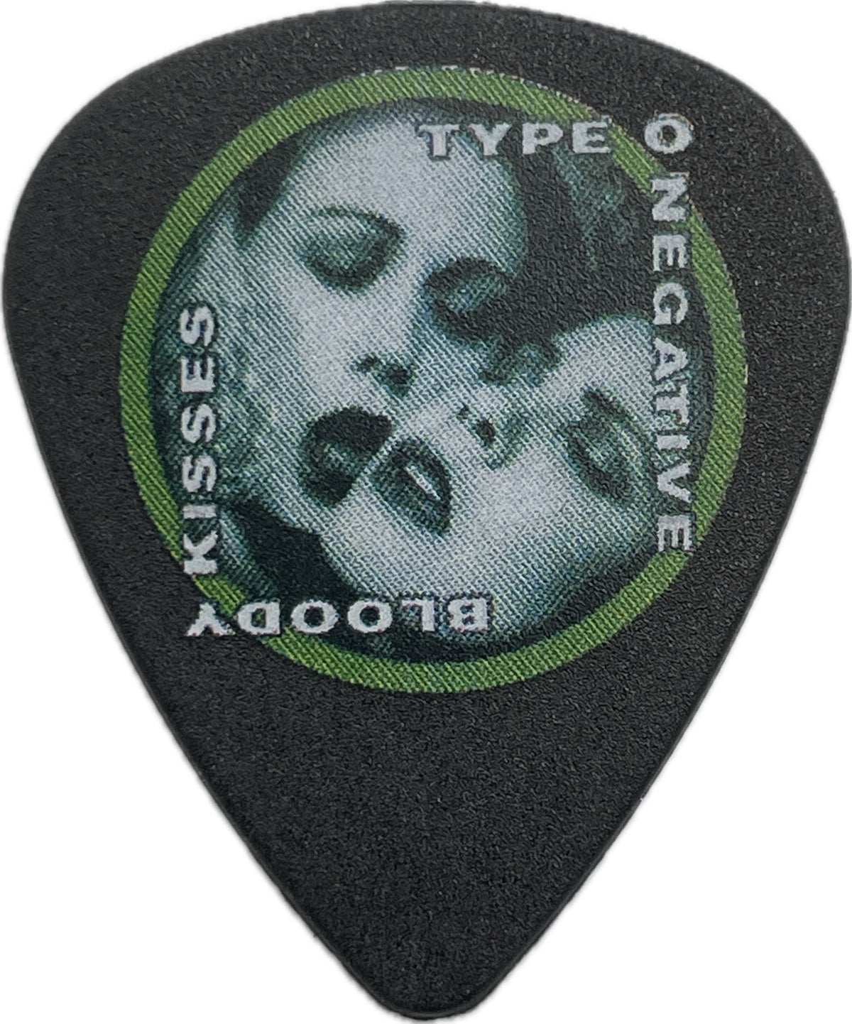 Front of a black Type O Negative Bloody Kisses guitar pick with a green circular border and skull artwork