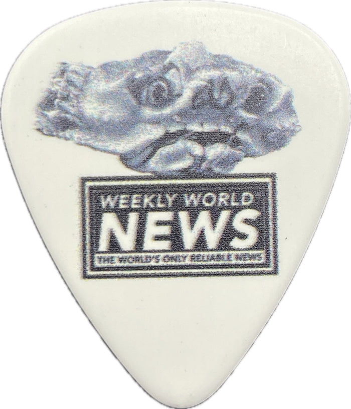 Weekly World News crab artwork on a white guitar pick